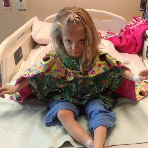 Girl in hospital bed with cape