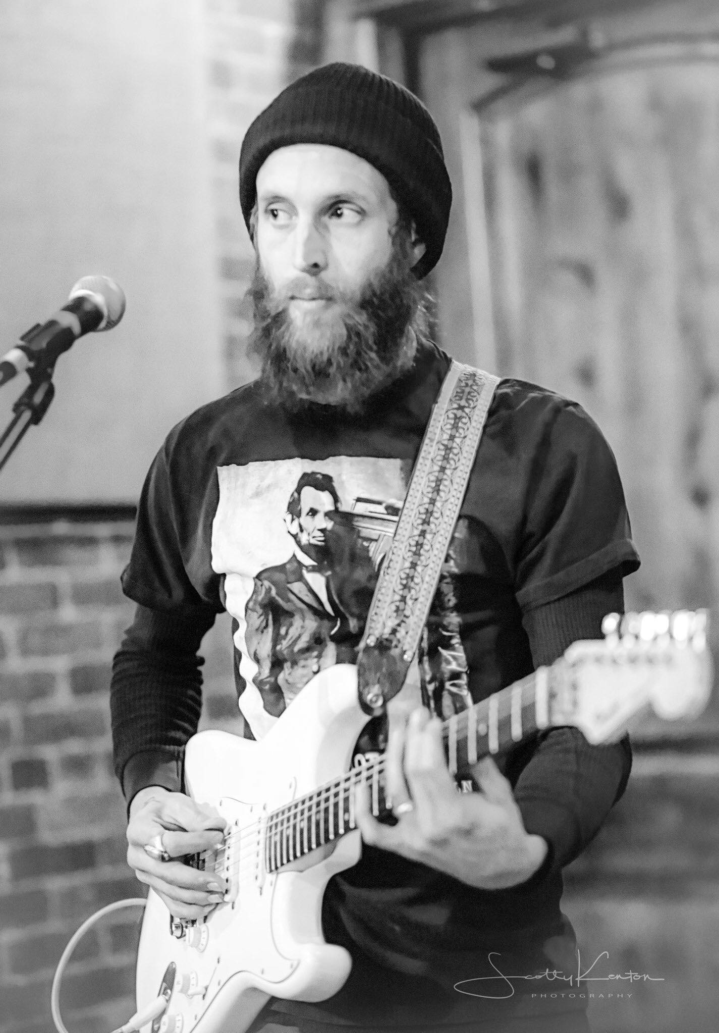 Man with a beard playing guitar